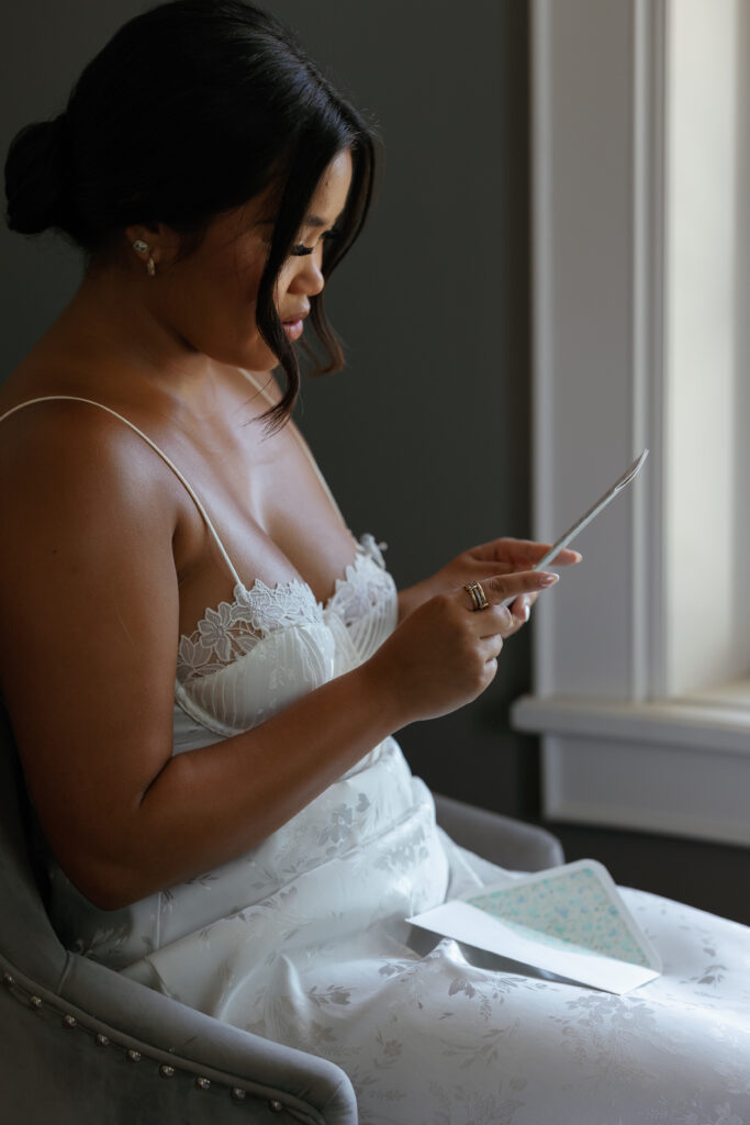 Bride in her getting ready slip, reading a handwritten note from her groom was a sweet moment during this Texas wedding.