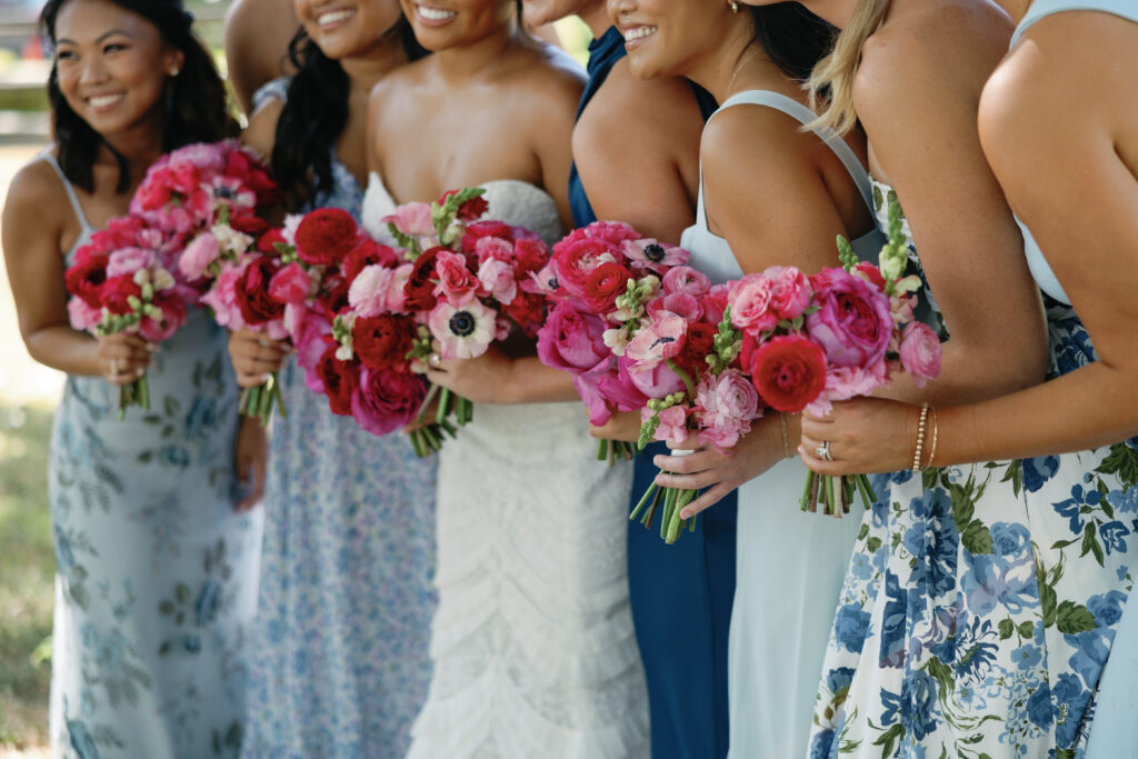 Bright pink wedding florals paired with blue bridesmaids dresses. 