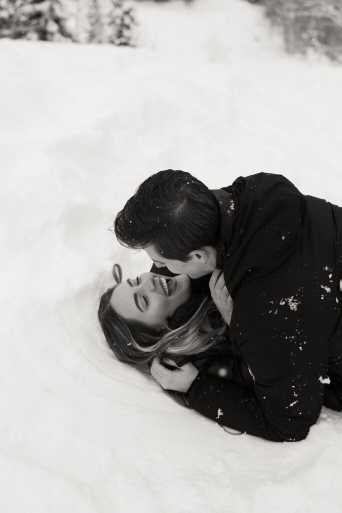 Fiancees pictured rolling in the snow during their engagement photos.